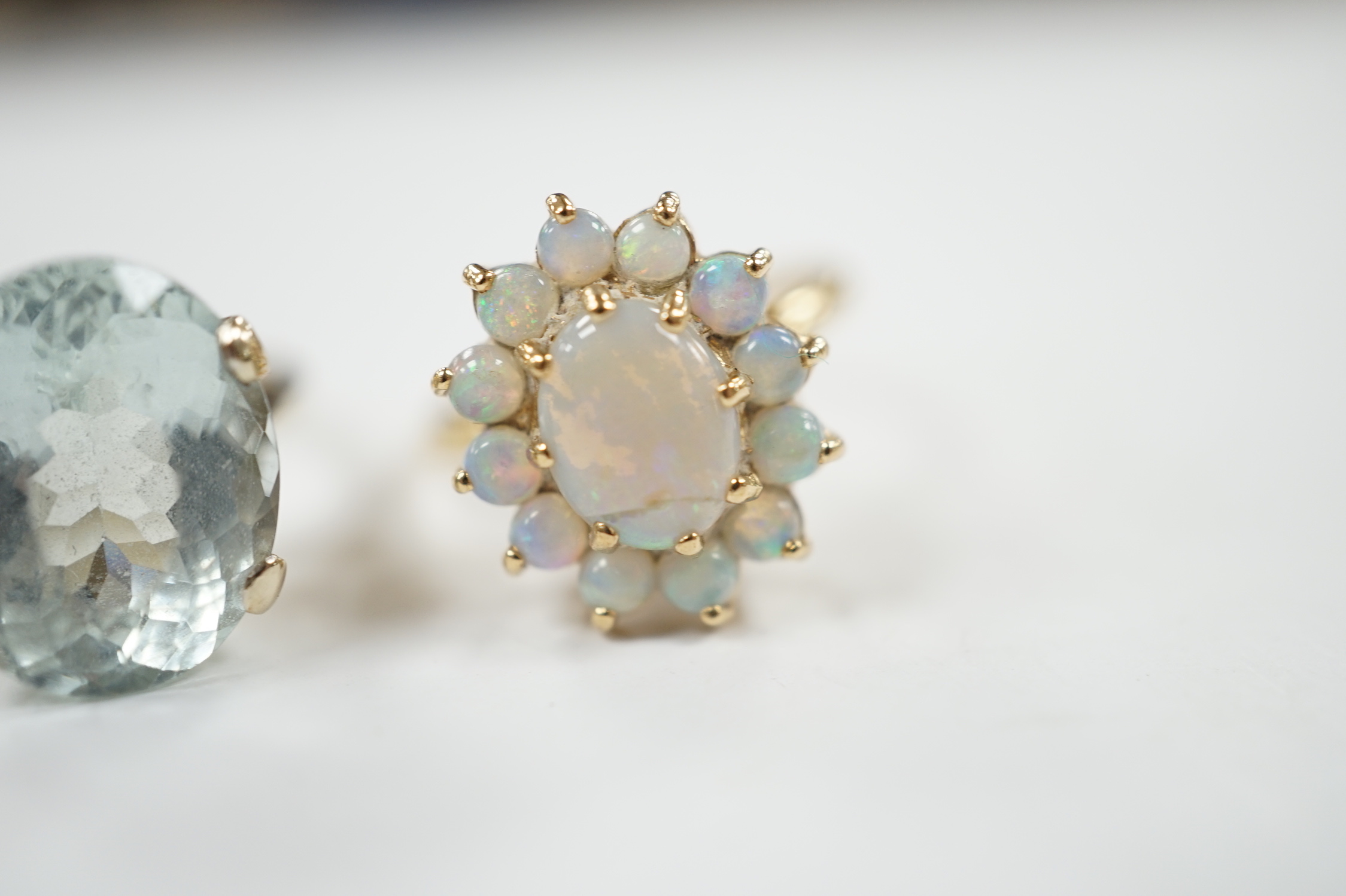 A 14k yellow metal and white opal set oval cluster ring, size P/Q, gross weight 4.1 grams and a gilt white metal? and oval fancy cut aquamarine set ring.